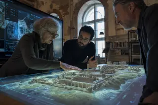 team of cultural professionals collaborating around an interactive 3D heritage model in a digital lab